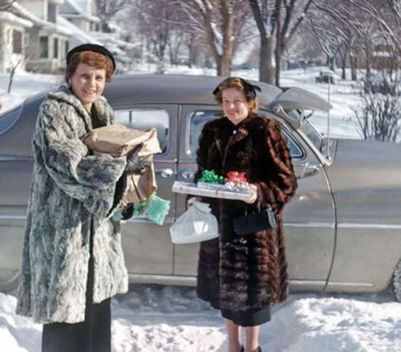 Splendette vintage inspired 1950s Christmas imagery of two woman carrying gifts in the snow from a classic American car