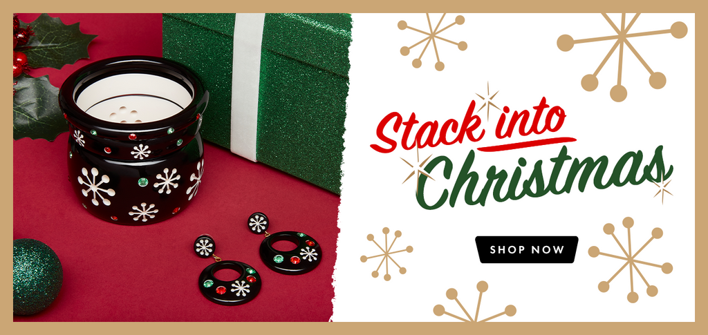 Splendette vintage inspired 1950s Christmas style jewellery. White Lumi and black Musta Atomic Snowflake bangle stacks with Christmas decorations and presents in the background.