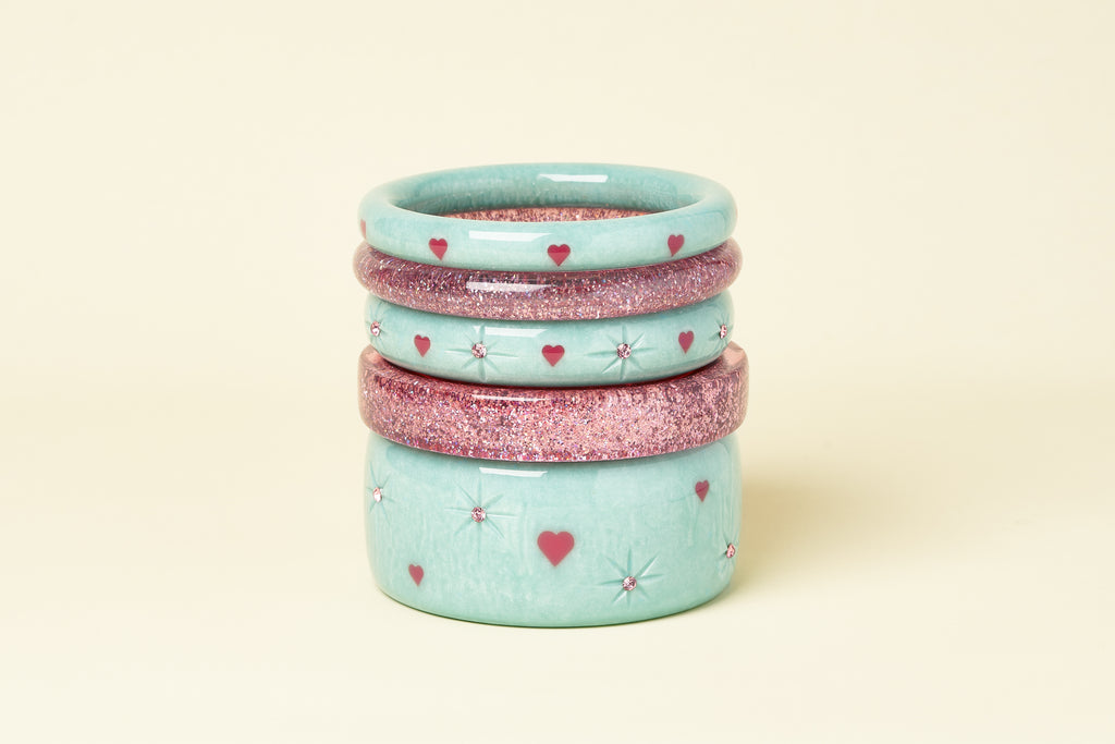 Splendette vintage inspired 1950s Valentine's style pastel blue Baby Doll and Pale Pink Glitter bangles in a stack