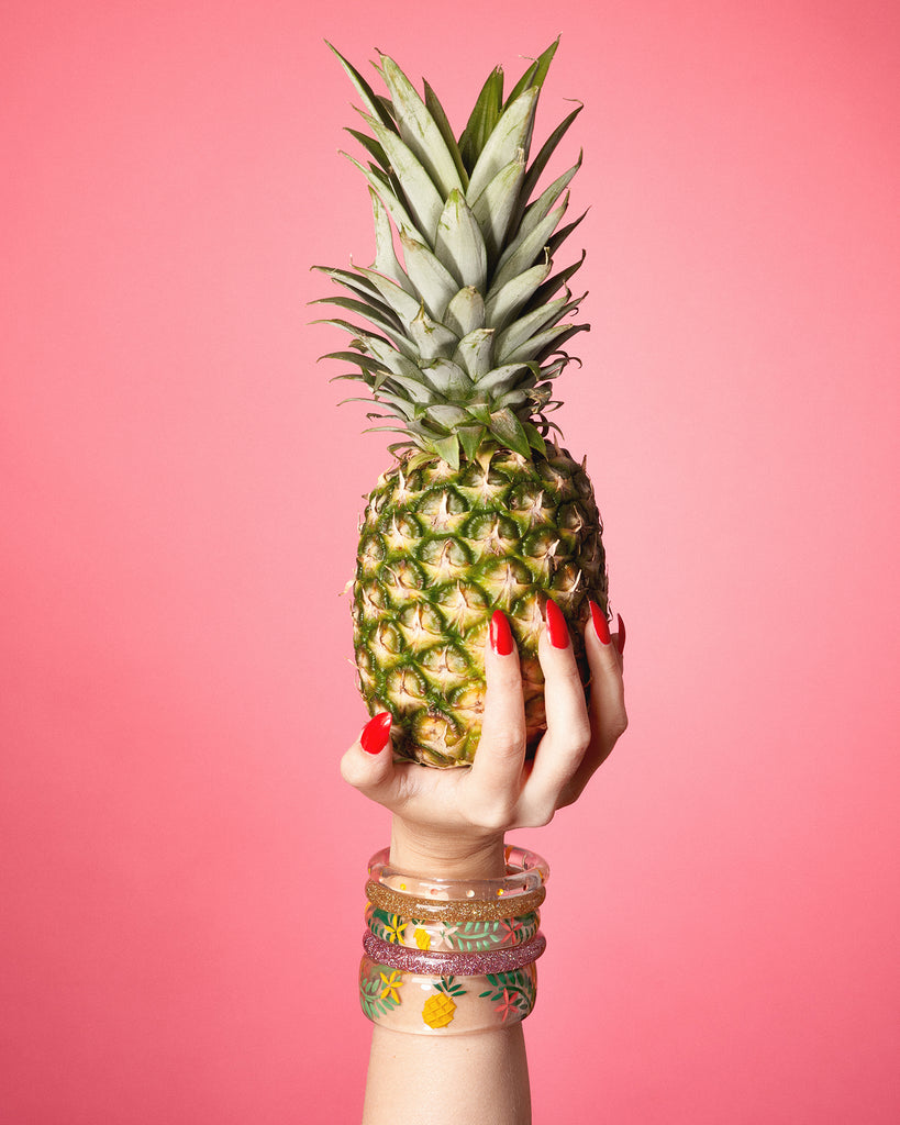 Splendette vintage inspired 1950s retro tropical style Pineapple fakelite jewellery with hand model holding a pineapple