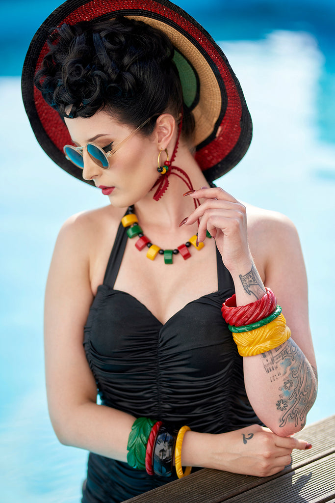Splendette vintage inspired 1940s style model wearing heavy carve fakelite jewellery, including bangles necklace and earrings