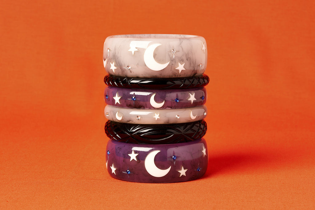 Splendette vintage inspired 1950s Halloween style Black, white Spectre and purple Poison bangles in a stack on an orange background