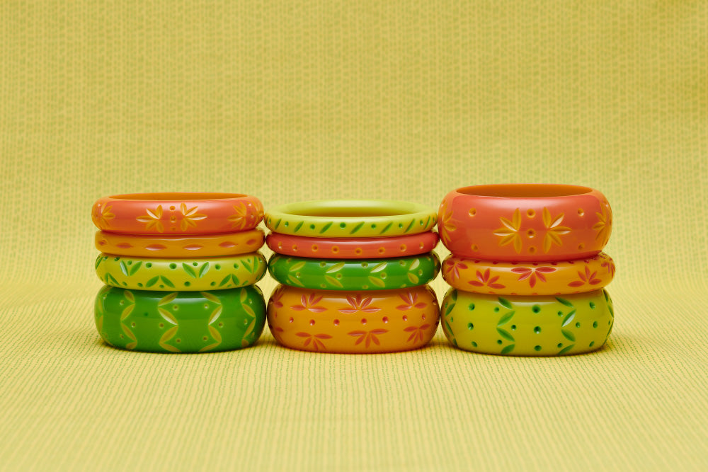 Splendette vintage inspired 1950s style peachy orange, yellow and bright green carved Spring 2021 Duotone fakelite bangles in three stacks. Honeysuckle, Freesia, Lime and Zest